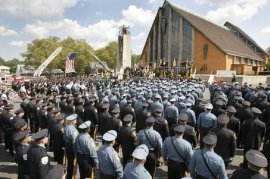 Hundreds of law enforcement officers and firefighters from across the state stand at attention at the funeral mass for Kenneth Santucci at Holy Family Church in Nutley.